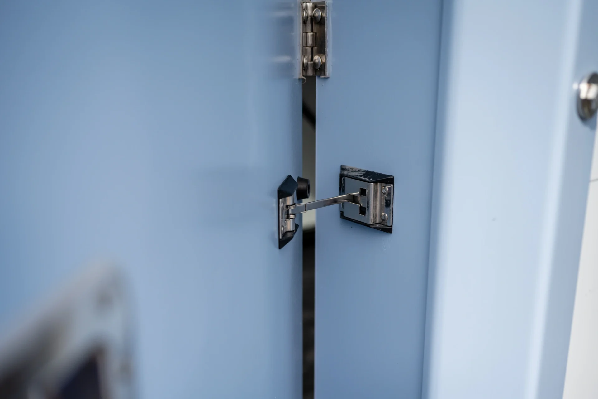 A corner of a room with two doors and a door handle.