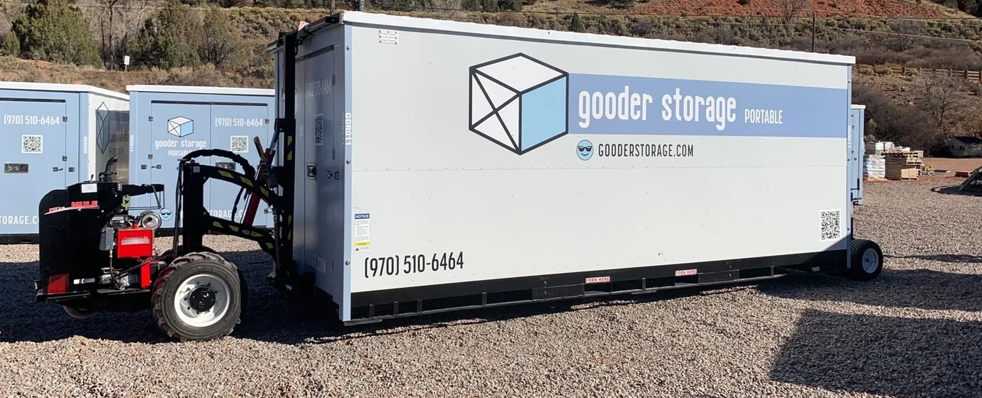 A white storage container sitting on top of gravel.