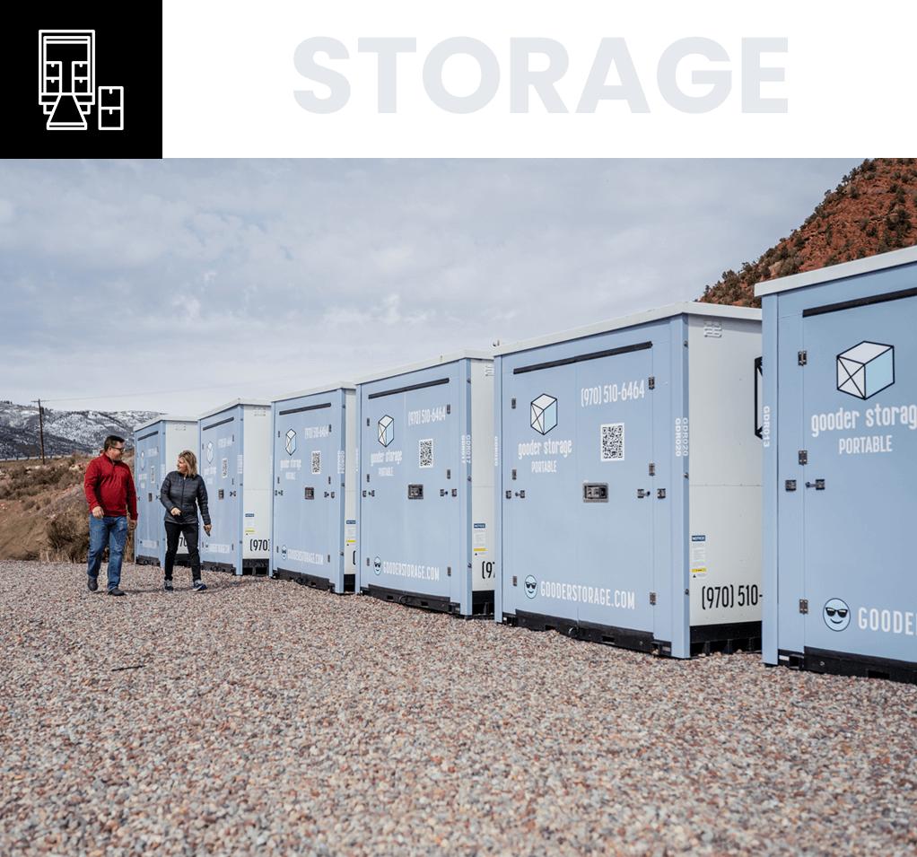 Two people standing in front of a row of blue storage containers.