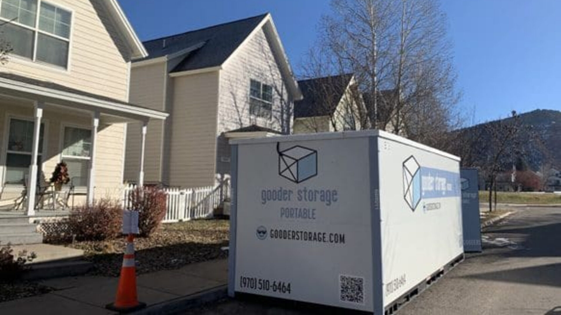 A white moving truck parked in front of a house.