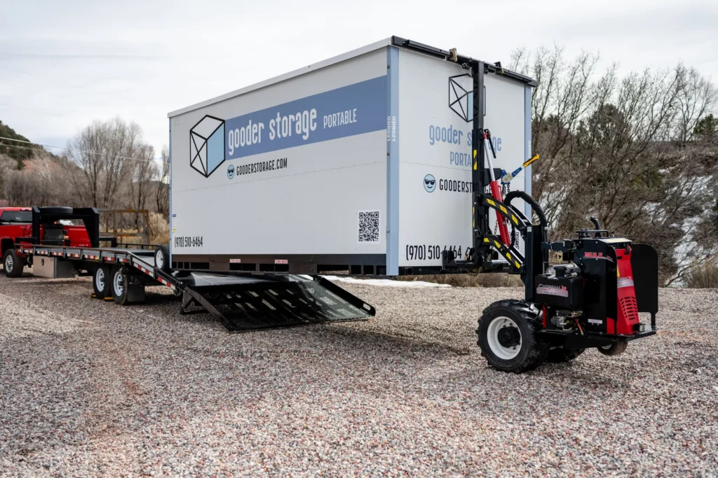 Gooder's remote-controlled delivery bot unloading a mobile storage box from the delivery trailer