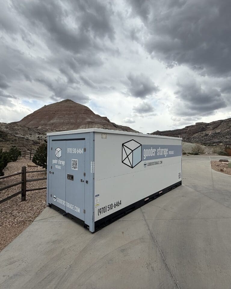 Gooder mobile storage box parked on a driveway below red rock mesas in the Grand Valley