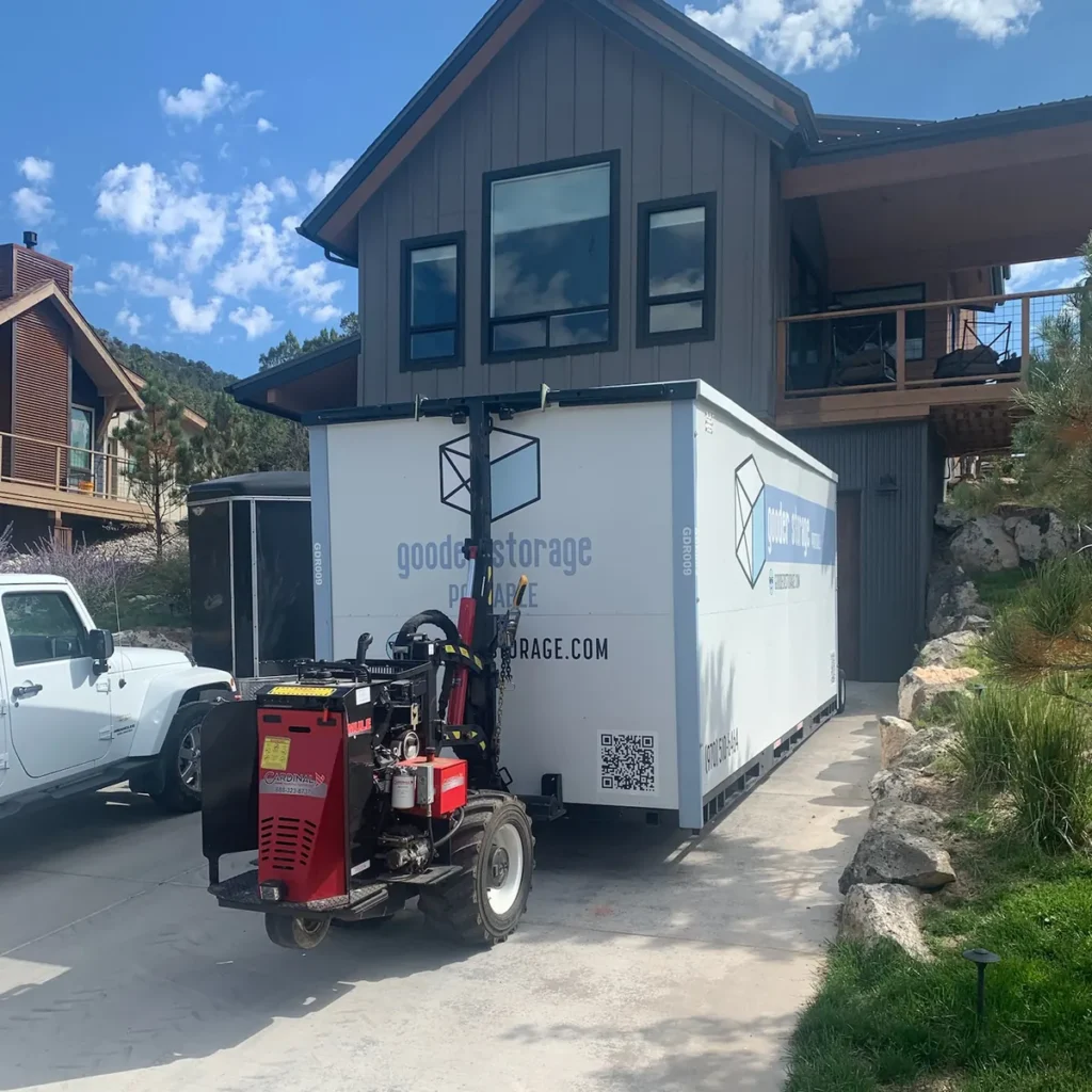 Gooder's remote-controlled delivery bot backing a mobile storage box into a tight residential driveway